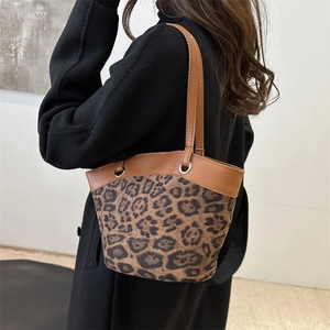 Retro Schultertasche mit Leopardenmuster und Lederriemen getragen von einem Model