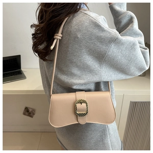 Chic beige shoulder bag with gold buckle on a model in a modern office setting