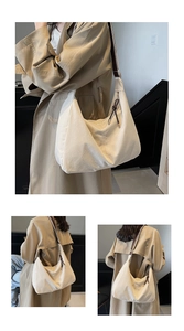Détail du sac hobo en toile crème avec bandoulière marron et nœud en cuir au zip