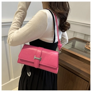 Close-up of pink faux crocodile leather shoulder bag with silver H-buckle and knotted strap