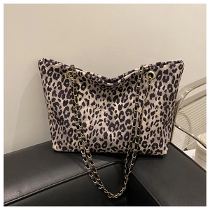 Detail of leopard print tote bag featuring gold chain and leather shoulder strap