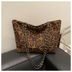 Close-up of leopard print tote bag with gold chain strap and textured fabric detail