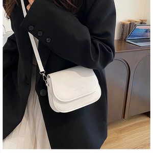 Sacoche selle blanche portée par un mannequin en blazer noir pour un style moderne