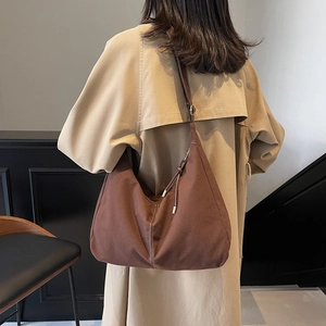 Sac fourre-tout minimaliste en daim marron porté par un mannequin avec bandoulière