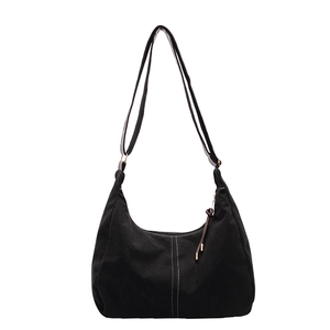 Large black canvas crescent tote bag with white contrast stitching and adjustable strap