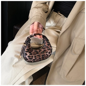 Close-up of mini leopard print crescent bag with gold zipper and hardware accents
