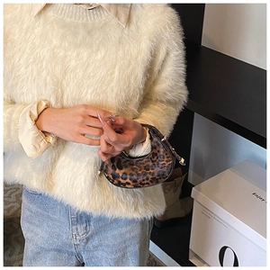 Detailed view of mini leopard print crescent bag with faux leather texture and hardware