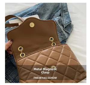 Close-up of golden magnetic hardware clasp on brown quilted diamond pattern bag
