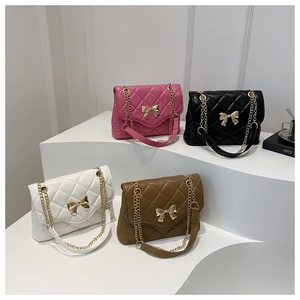 Detail of four quilted crossbody bags in rose pink, black, white, and brown with bow clasps