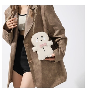 Détail d'un sac bandoulière en forme de bonhomme de pain d'épices avec nœud rose