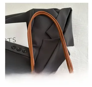 Detail shot of the comfortable brown leather handle and off-white canvas tote bag