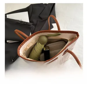 Top view of large capacity tote bag with white canvas and brown leather trim details