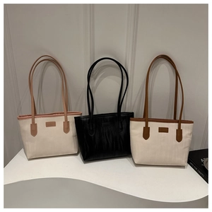 Three large tote bags in canvas and leather patchwork styles on minimalist display