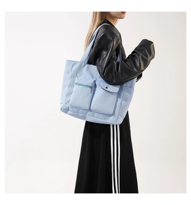Nahaufnahme der hellblauen Canvas-Tasche mit Multi-Taschen-Design an der Schulter