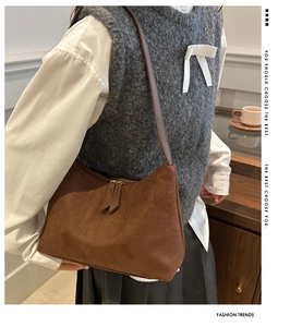 Detail of brown corduroy shoulder bag with double zippers and stylish long pullers