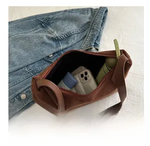 Internal capacity of brown suede shoulder bag showing space for phone and umbrella
