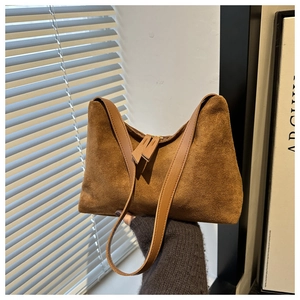 Brown suede underarm shoulder bag with golden zipper in a minimalist trapezoid style
