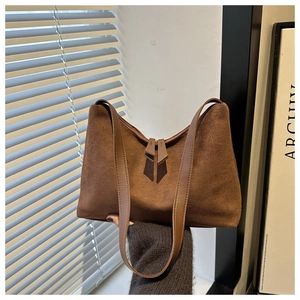 Brown frosted texture shoulder bag with dual handles and metal zipper in sunlight