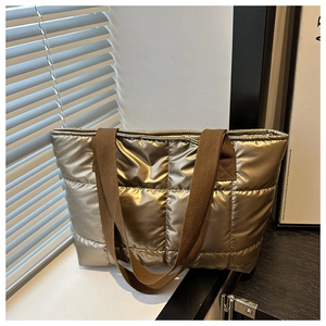Quilted down tote bag in metallic gold finish with spacious interior and soft padded straps