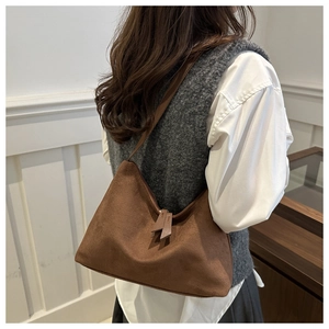 Detailed shot of brown suede hobo bag with fringe zip pullers for casual office look