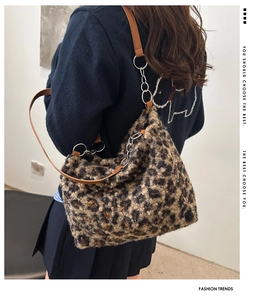 Detail of plush leopard print tote bag with brown leather strap and chain link
