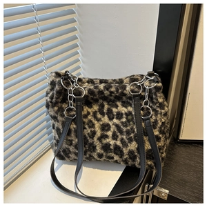 Detail of leopard print faux fur texture and silver metal chain strap on tote bag