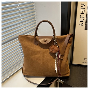 Détail du sac cabas en daim caramel avec rabat en cuir et pendentif ours mignon
