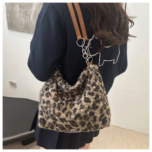 Detail of leopard print plush tote bag featuring double metal chain and leather straps