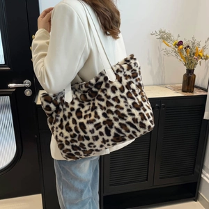 Fashionable leopard print plush tote bag with white leather straps shown in a modern home