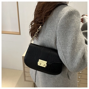 Detail of black crocodile texture bag with gold square clasp and chunky chain strap