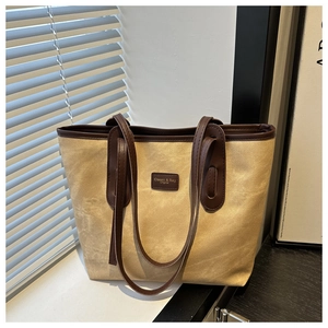 Detail of vintage tote bag showing khaki suede texture and classic leather brand label