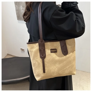 Detail of vintage canvas tote bag featuring brown leather trim and sturdy handles