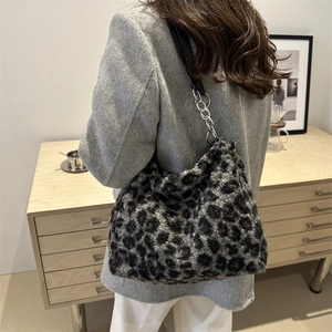 Fuzzy leopard print plush tote bag with silver chain strap shown on a model's shoulder