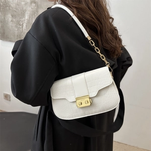 White crocodile pattern crossbody bag with gold metal lock and chain strap on shoulder