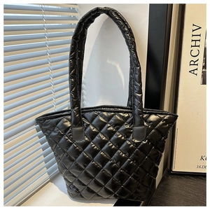 Détail du sac cabas matelassé noir avec coutures en losanges brillantes sur le tissu