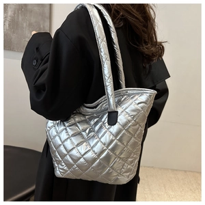 Gros plan d'un grand sac cabas argenté matelassé avec une finition métallique chic