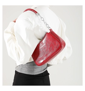 Detail of red marble textured crescent bag with silver chain and white fashion text
