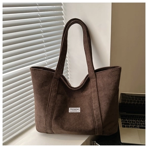Detail of coffee brown corduroy tote bag showing ribbed texture and fashion label