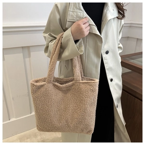 Detail of soft beige plush tote bag with thick shoulder straps and fluffy texture