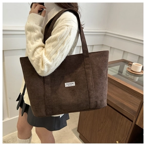 Detailaufnahme der dunkelbraunen Cord-Tasche mit grober Struktur und Markenetikett
