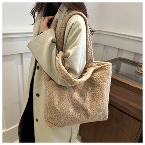 Detail of plush beige sherpa tote bag showing soft curly faux fur texture and sturdy handle