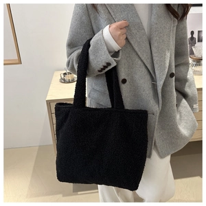 Close-up of fluffy black faux fur tote bag showing plush texture and winter style