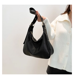 Close-up of black Hobo tote bag showing smooth leather texture and gold hardware detail