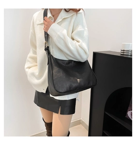 Female model wearing a black large capacity hobo shoulder bag with textured finish
