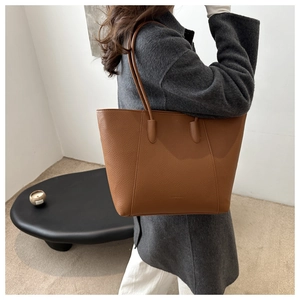 Brown leather tote bag side view on female model showing size and slouchy silhouette