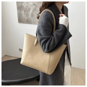 Gros plan sur le sac cabas en cuir beige grainé montrant la texture et le logo