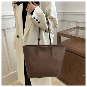 Vue détaillée d'un sac cabas en cuir marron foncé avec texture grainée et fines anses