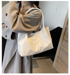 Off-white large capacity tote bag shown on shoulder with minimalist styling