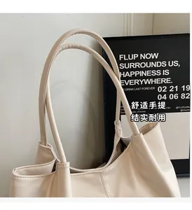 Detail of reinforced long handles on a minimalist cream-white large capacity tote bag