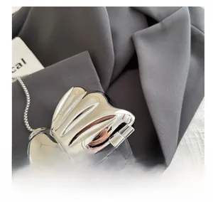 Close-up of silver mirror-finish acrylic mini bag with sleek metallic chain strap